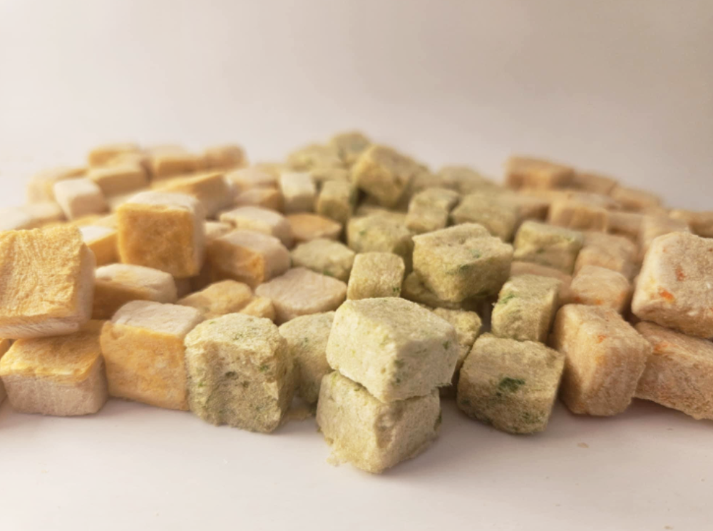 Close up of Chicken and Carrot, Chicken Green Bean, Chicken Sweet Potato. Crunchy dog treats in cube shape for easy training, rewards, and meal toppers. Raw diet friendly Pet Treats.